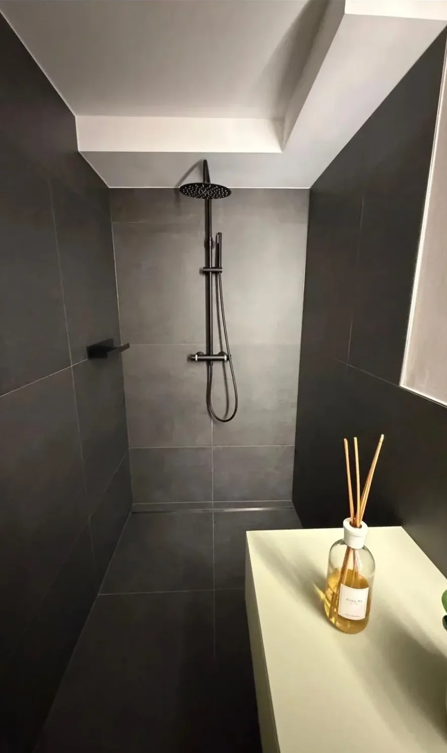 Bodenebene Dusche mit Feinsteinzeugfliesen in Anthrazit und schwarzer Regenbrause