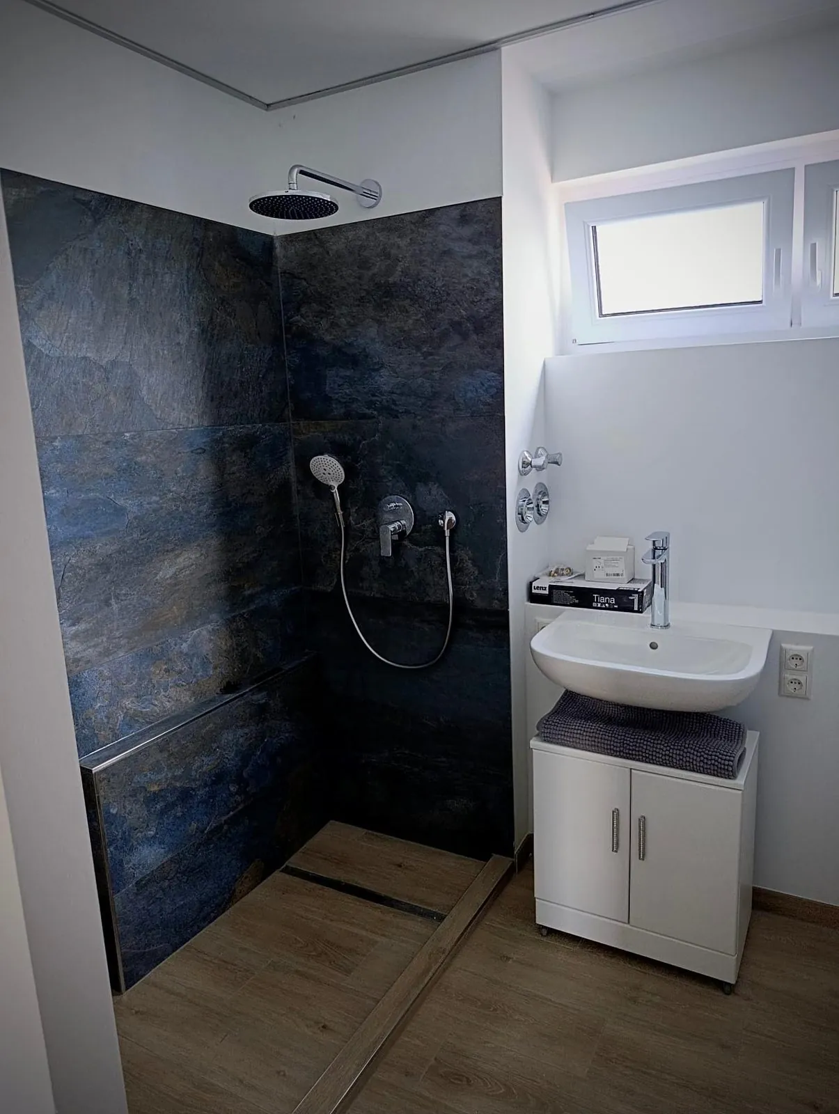 Bodengleiche Dusche mit dunklem Schiefer-Naturstein an den Wänden und Holzoptik-Fliesen am Boden, Projekt in Ingelheim am Rhein